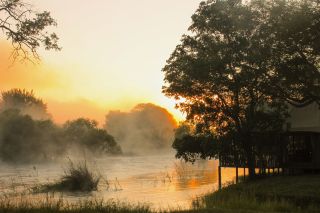 Zambezi Sands River Camp; Sonnenaufgang und Nebel über dem Sambesi