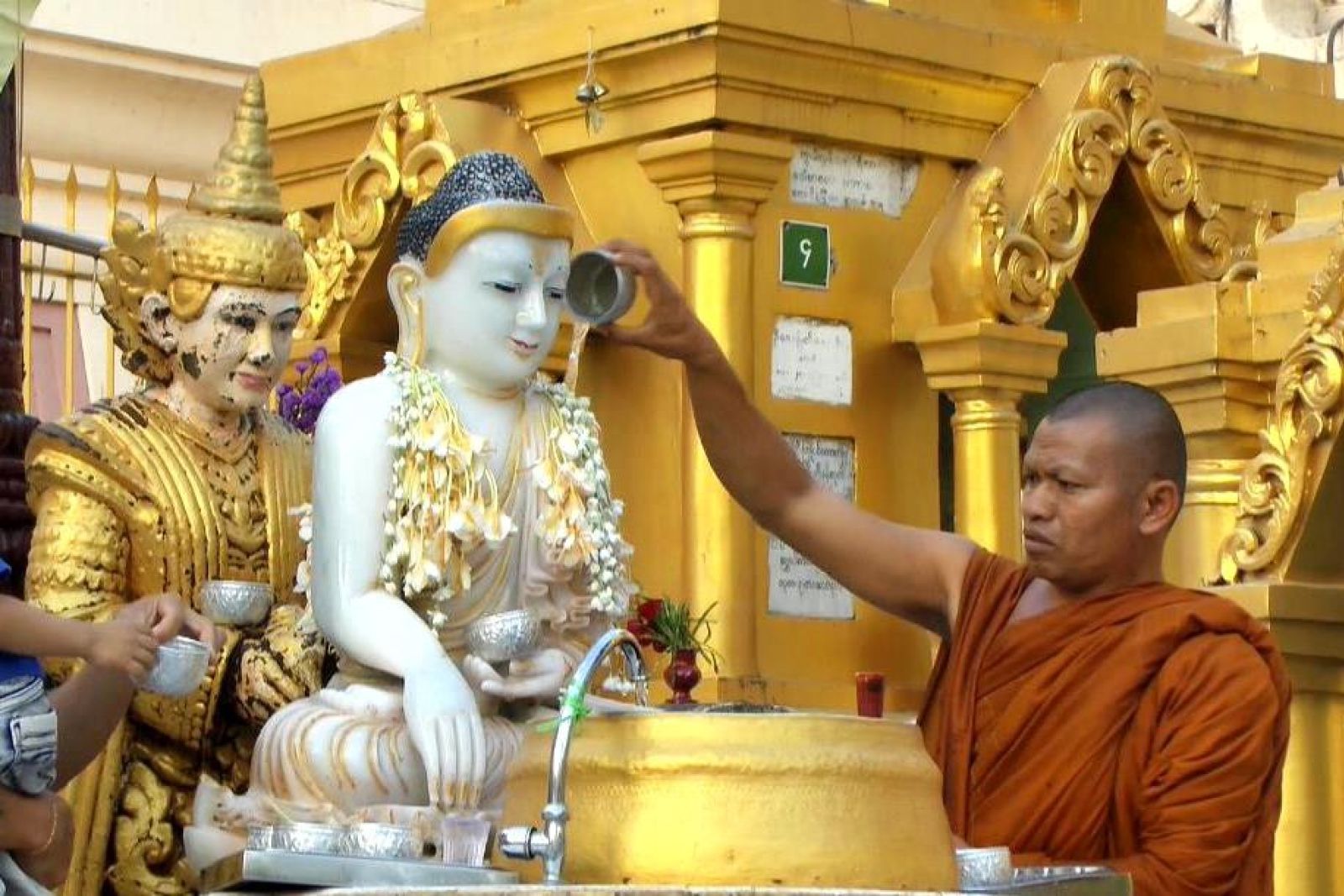 Als Zeichen der Ehrerbietung werden Buddha-Figuren mit Wasser übergossen.