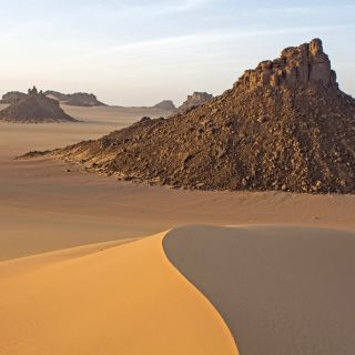 Felsformationen und gelb-rote Dünen der Sahara