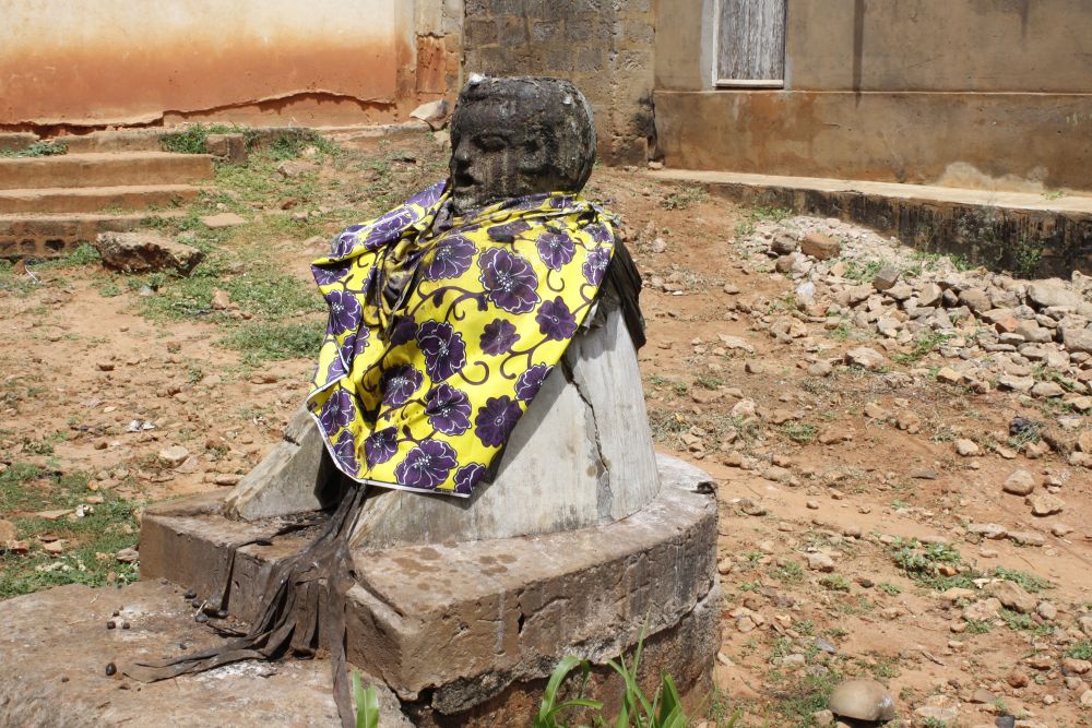 Legba Statue in Togoville. Legba ist der Hüter der Wegkreuzungen und ist vor allem in Nigeria, Benin und Togo in jedem Dorf anzutreffen. Er beschützt das Dorf/die Stadt und seine Bewohner und erhält von diesen Geschenke und Opfergaben zurück.