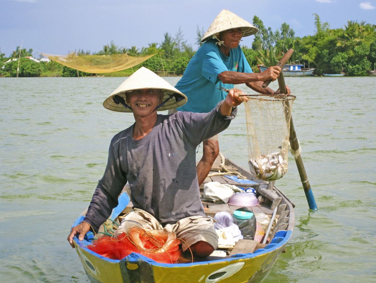 Fröhliche Fischer mit ihrem Fang in Hoi An