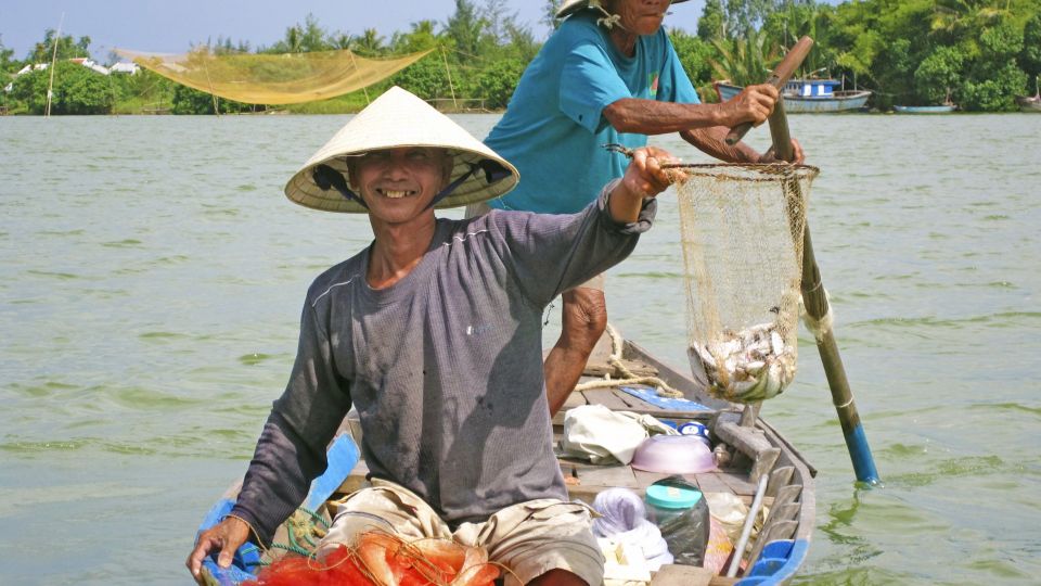 Fröhliche Fischer mit ihrem Fang in Hoi An