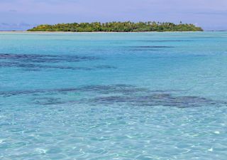 Glasklares Wasser mit Korellenbänken in der Lagune von Aitutaki