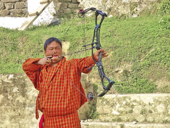 Bhutaner in traditioneller Kleidung beim Bogenschießen