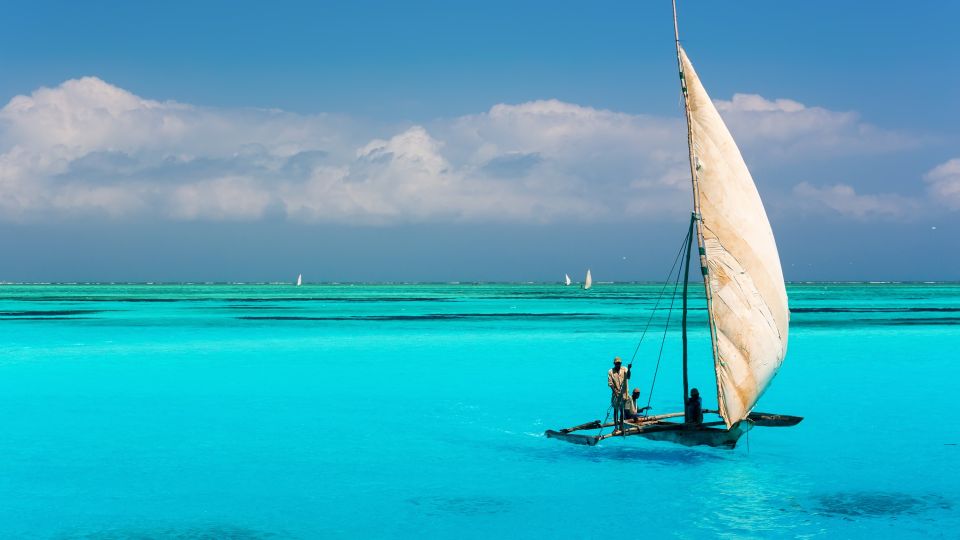 Katamaran auf türkisfarbenem Wasser im Indischen Ozean nahe dem Mnemba Atoll auf Sansibar
