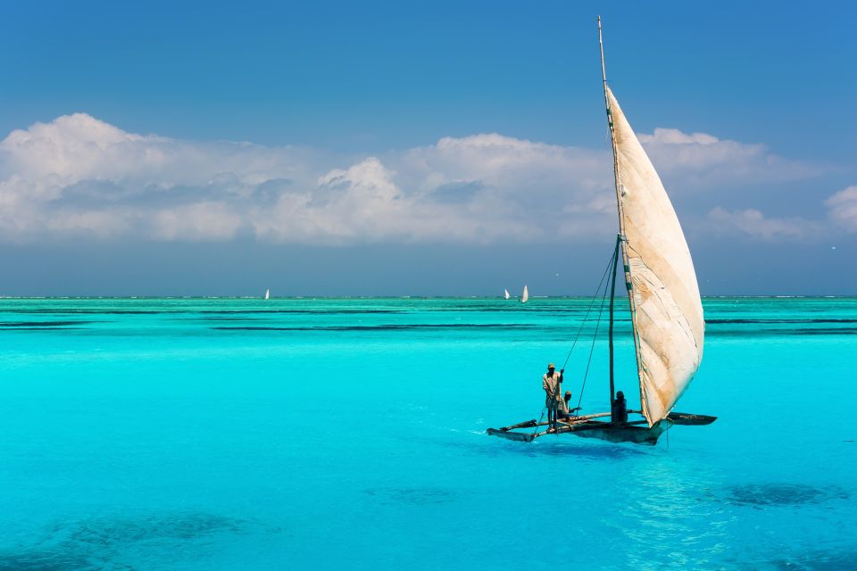 Katamaran auf türkisfarbenem Wasser im Indischen Ozean nahe dem Mnemba Atoll auf Sansibar