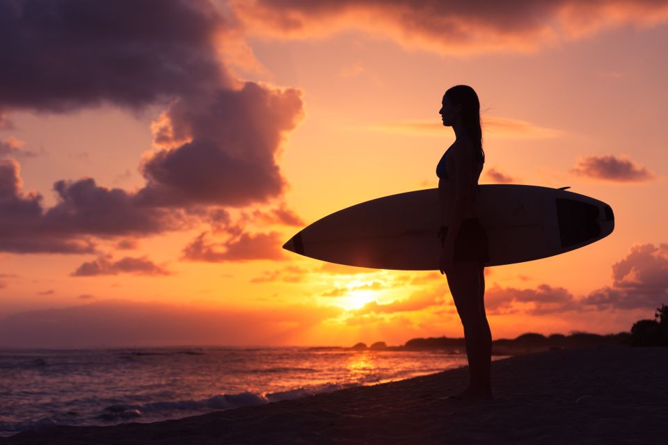 Surferin am Strand vor Sonnenuntergang