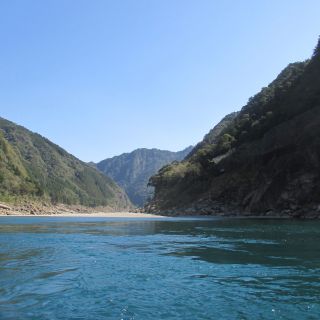 Kristallklares Wasser vor einer traumhaften Bergkulisse erleben Sie bei einer Bootsfahrt auf dem Kumano-Fluss.