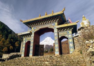 Tor zum Kloster Ribung in Lho – im Hintergrund der mächtige Manaslu