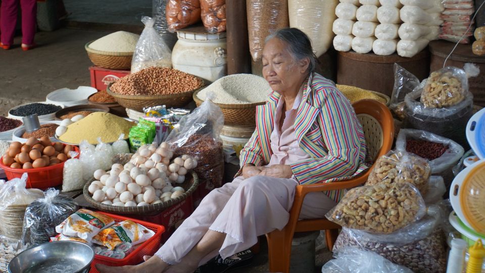Dösende Verkäuferin auf dem Wochenmarkt in Hue