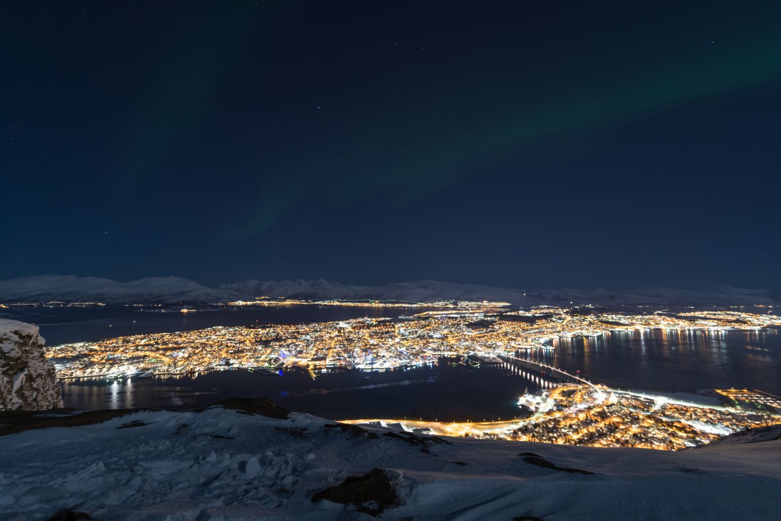 Blick auf Tromsö mit zarten Nordlichtschleiern