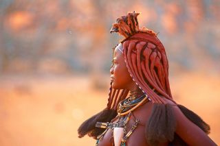 Junge Himbafrau mit traditioneller Frisur und Halsketten