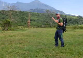 Reiseleiter Uwe Jeremiasch vor dem Mount Meru und einer Giraffe, Arusha NP