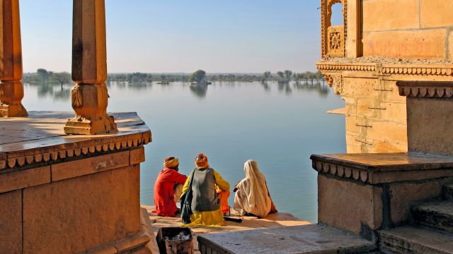 heilige Männer halten mit einer Frau einen Plausch am See von Jaisalmer