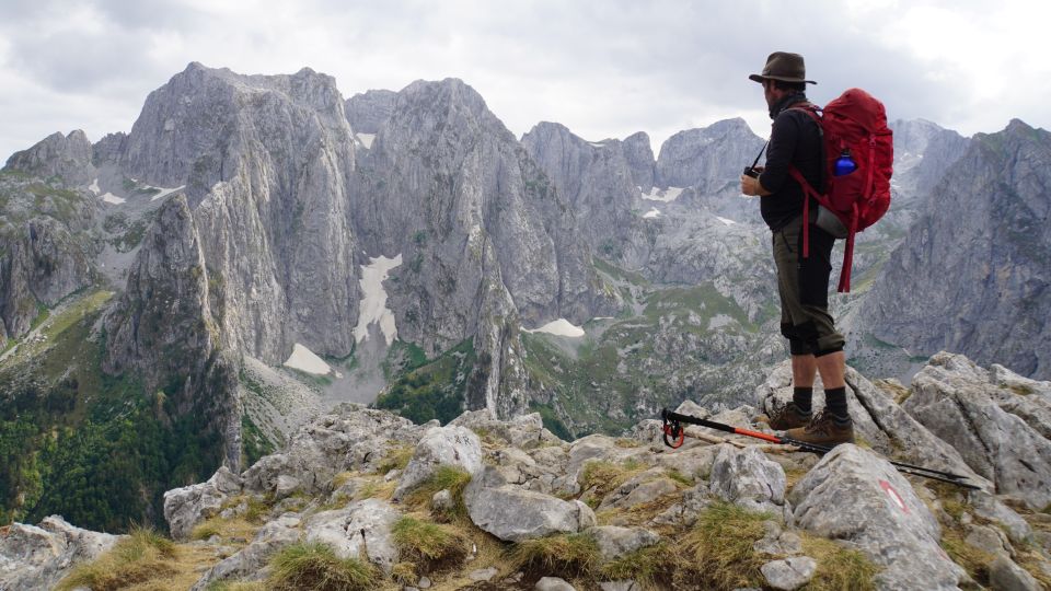 Wanderer vor ehrfurchtsgebietender Felswand im Prokletije-Nationalpark, Montenegro, oberhalb des Grbaja-Tals