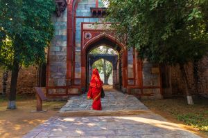 Inderin im roten Sare vor dem Eingang zum Humayuns Grabmal (UNESCO) in New Delhi.