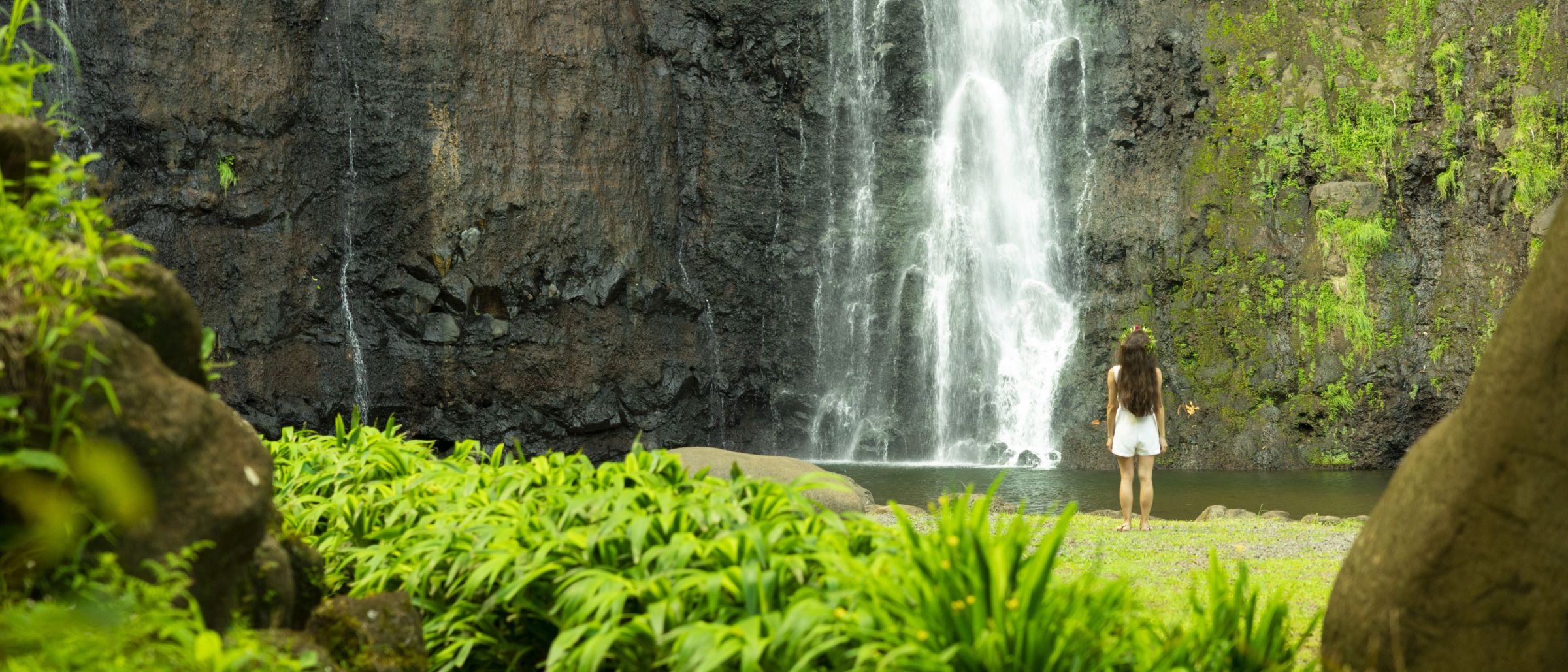 Frau vor einem Wasserfall in Tahiti – Französisch-Polynesien