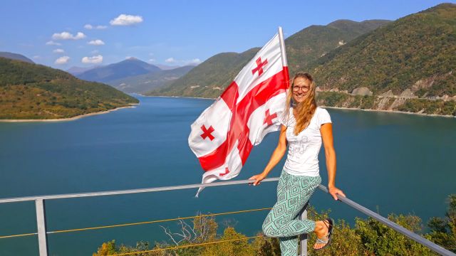 Kornelia Schau am Ananuri-Stausee mit georgischer Flagge