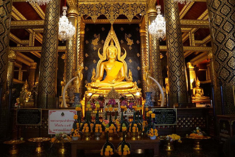 Kunstvolle Kratongs vor einer Buddha-Statue