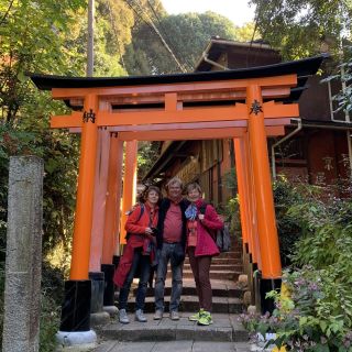 3 Gäste auf der Treppe einer Tempelanlage in Japan.