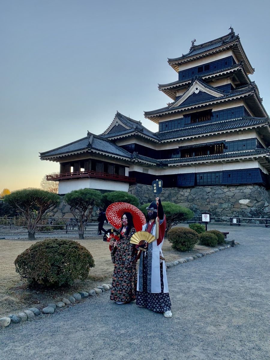 Japanerinnen in traditionellen Kleidern vor einer Tempelanlage