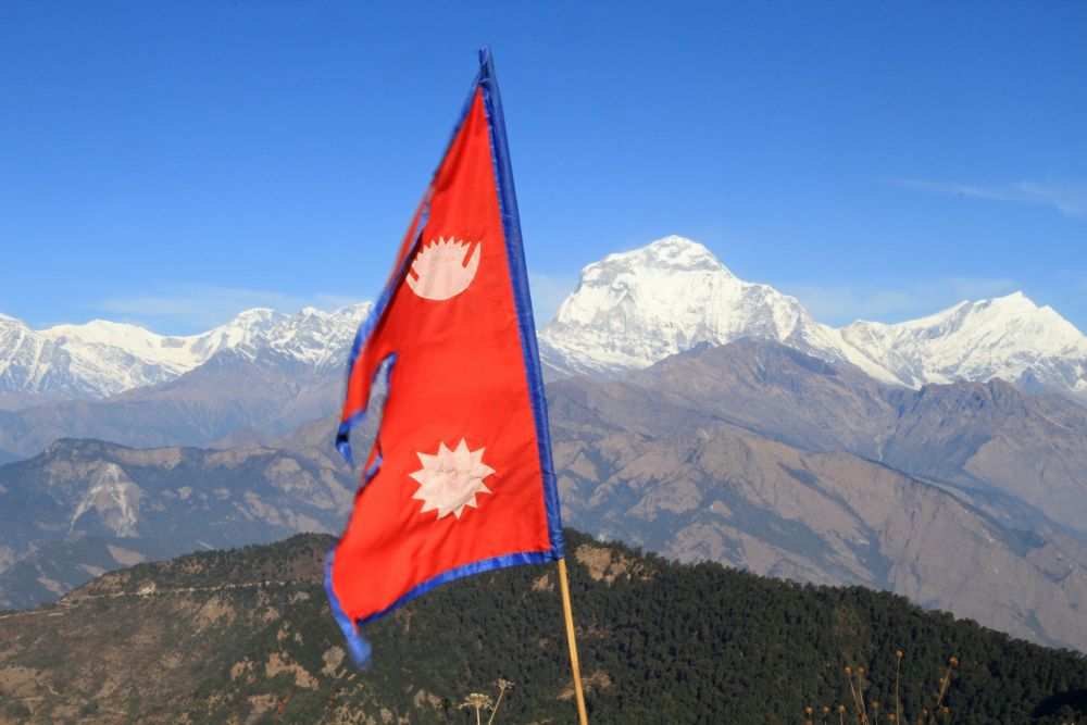 Die Nepal-Fahne auf dem Poon Hill weht vor dem 8167m hohen Dhaulagiri