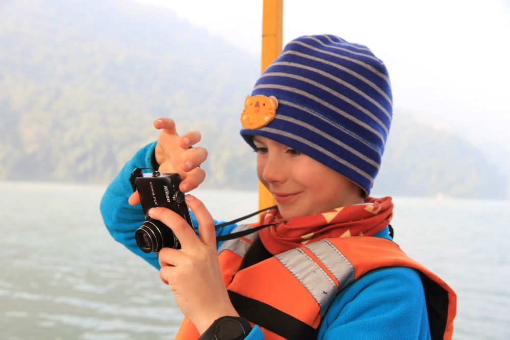 Kleiner Hobby-Fotograf bei der Bootsfahrt auf dem Phewa-See