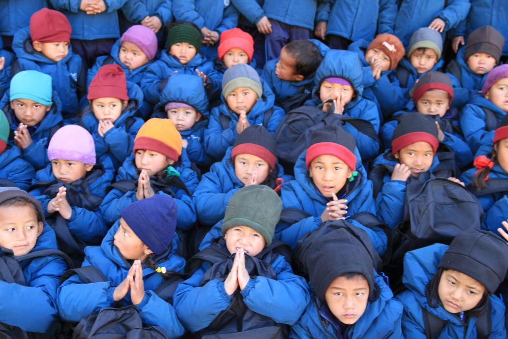 Schüler der Schule in Gunsakot mit neuen warmen Winterjacken und Mützen