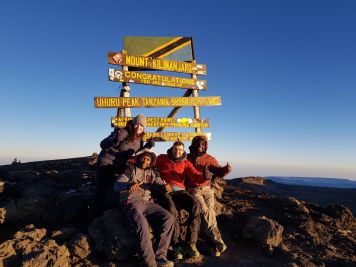 Glücklich auf dem Gipfel des Kilimanjaro