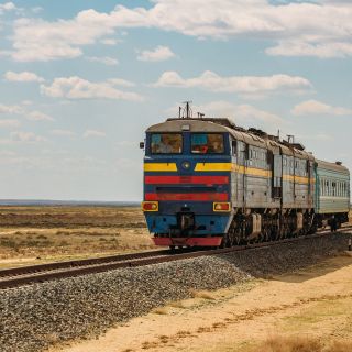 Lokomotive fährt durch die Wüste Kasachstans