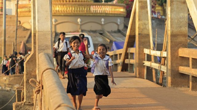 Schulkinder überqueren eine Brücke in Luang Prabang